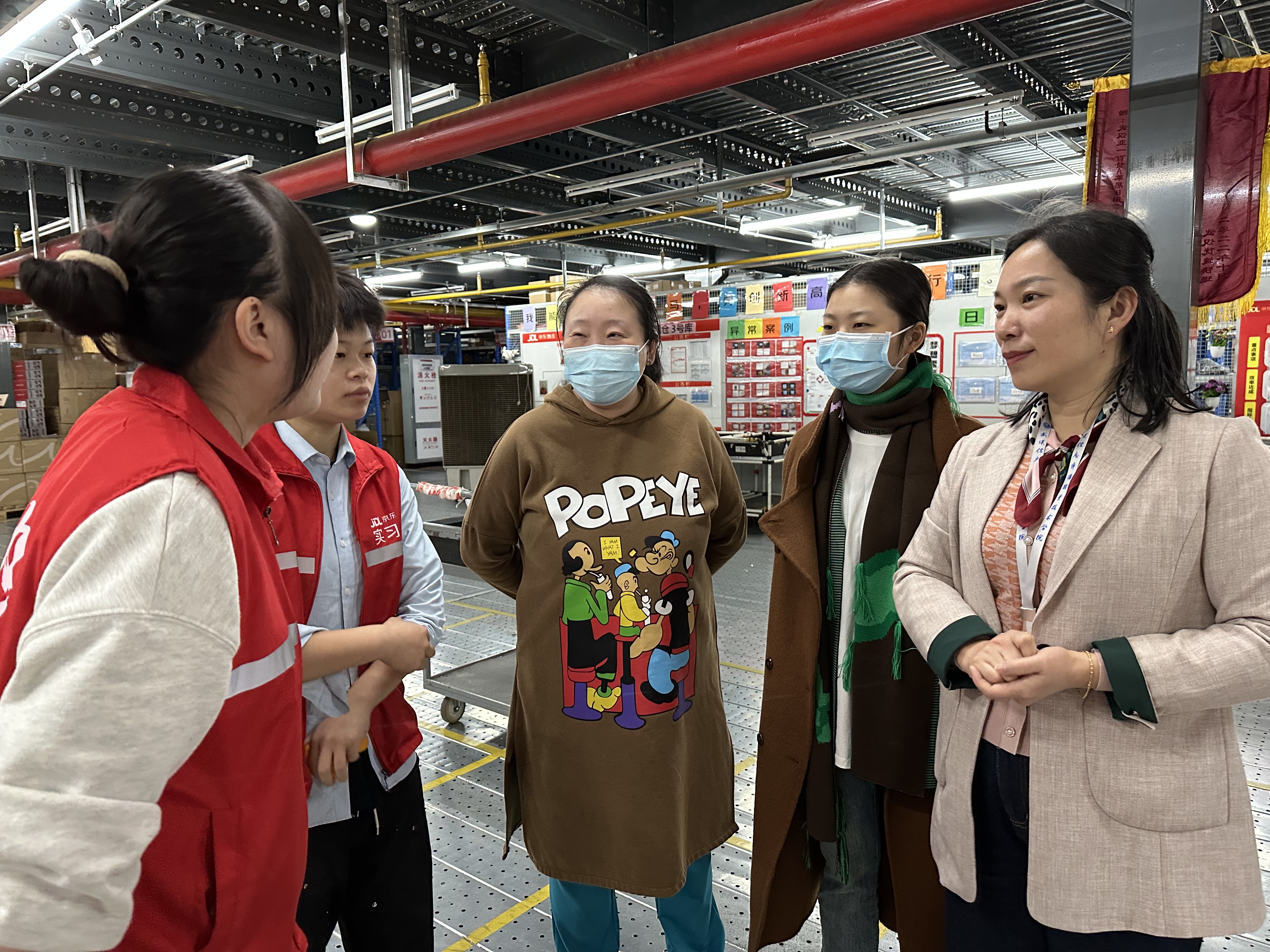 图4-2 商学院院长李静荣、副院长陈萍在仓里指导学生，与学生亲切交流